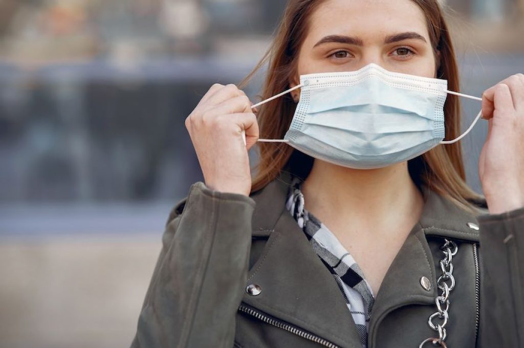 Woman in the city. Person in a mask. Coronavirus theme.