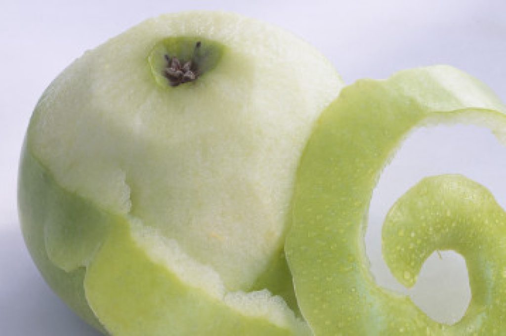 Partially peeled Granny Smith apple, close-up